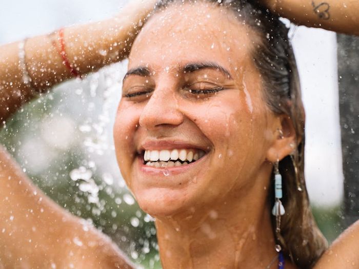 Smiling person stretching outdoors, feeling refreshed and full of life.